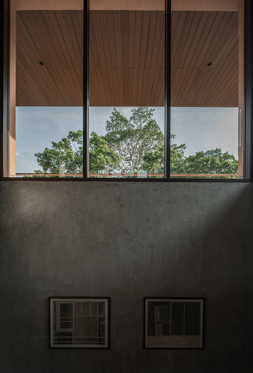 a pair of banyan trees anchors anonym studio’s open-air family house in thailand - 8