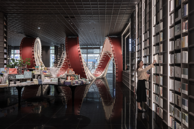 huge spiral staircase serving as a bookshelf takes over x+living's store in china