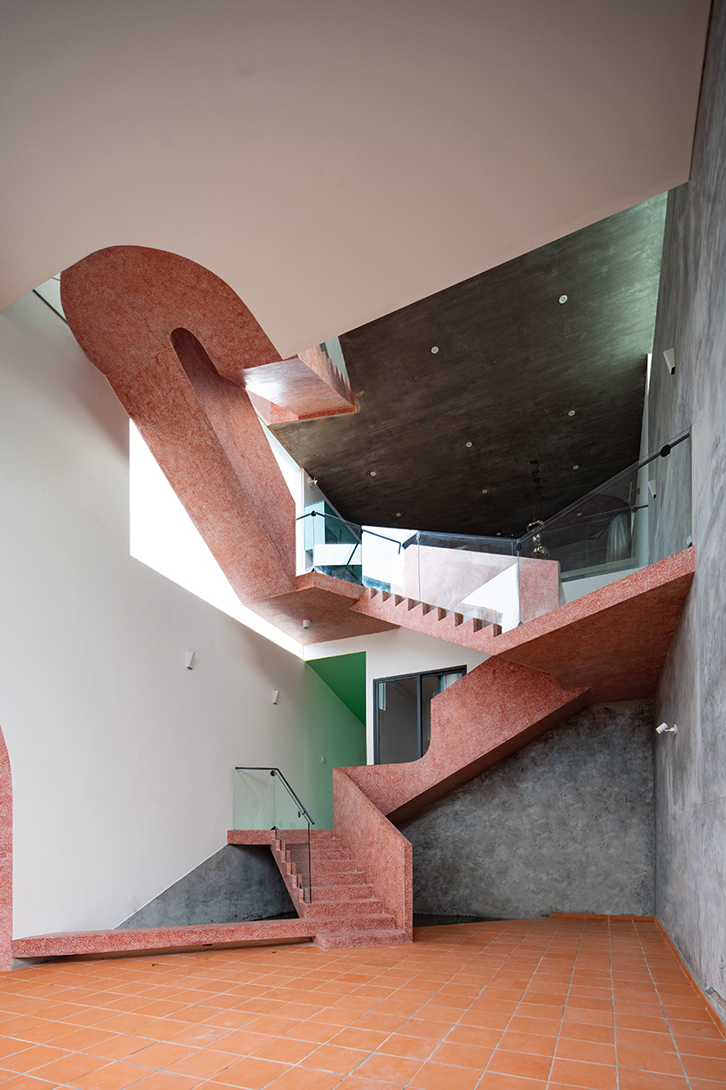 serpentine pink staircase highlights the inclination of AD+studio's house in vietnam