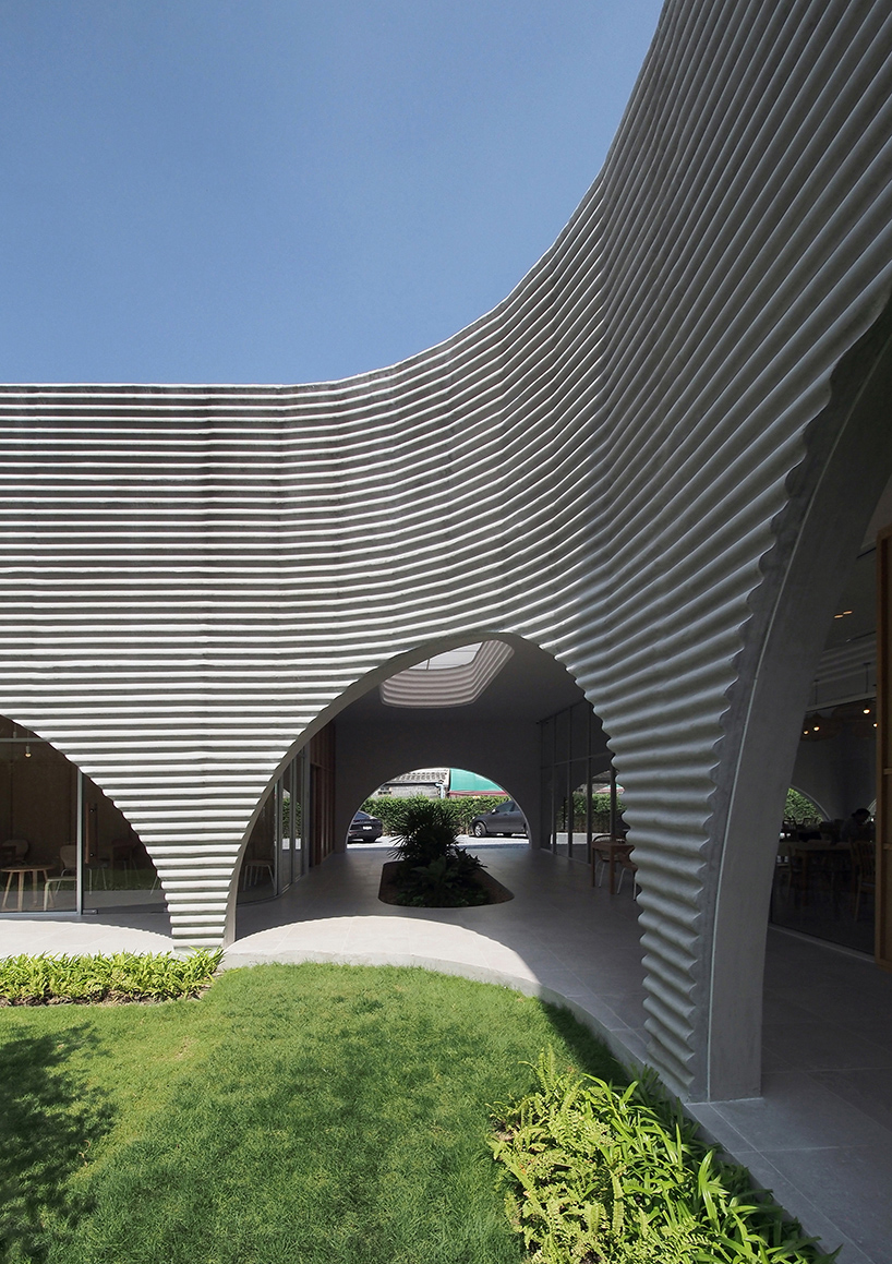 a new restaurant with a wavy precast facade that resembles a wave by aswa 4