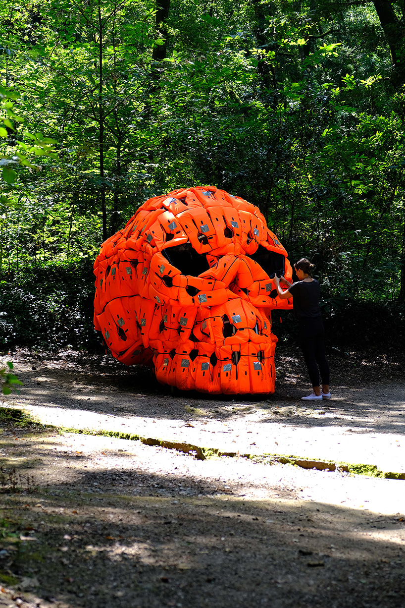 pedro pires sculpts large-scale skull using 140 life vests and rubber from a refugee dinghy designboom