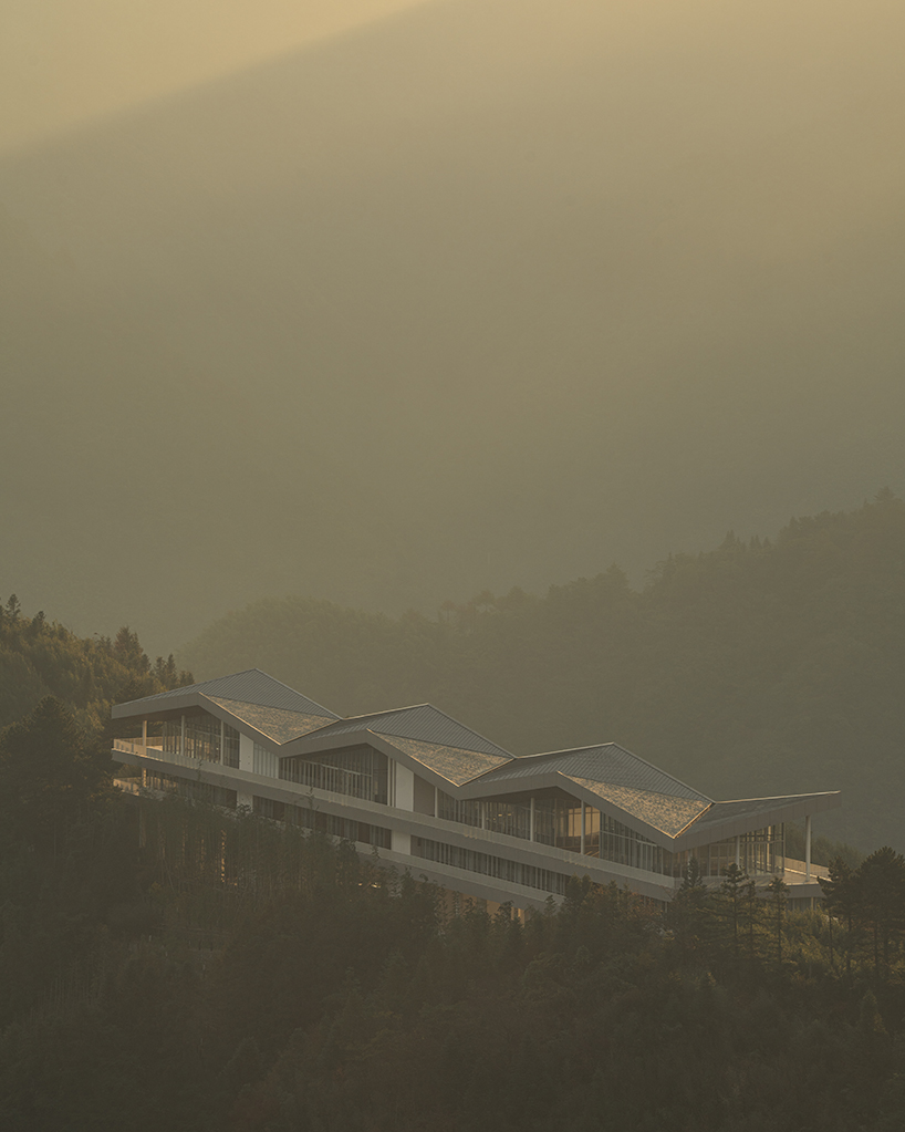 folded zinc roof undulates atop floating hotel by more architecture in china