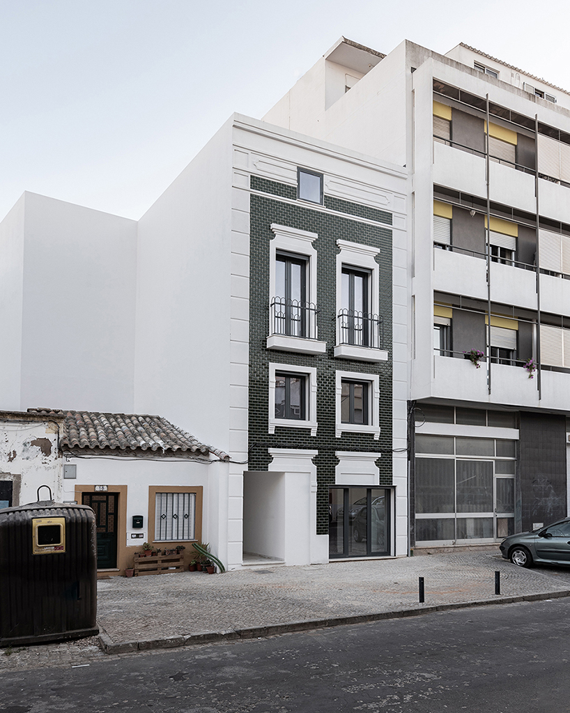 corpo atelier adheres tiled facade and window frame fragments to building in portugal