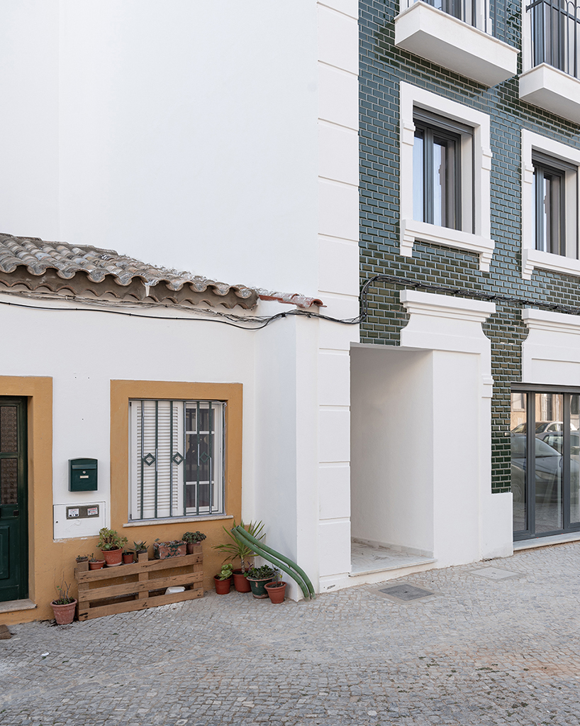 corpo atelier adheres tiled facade and window frame fragments to building in portugal