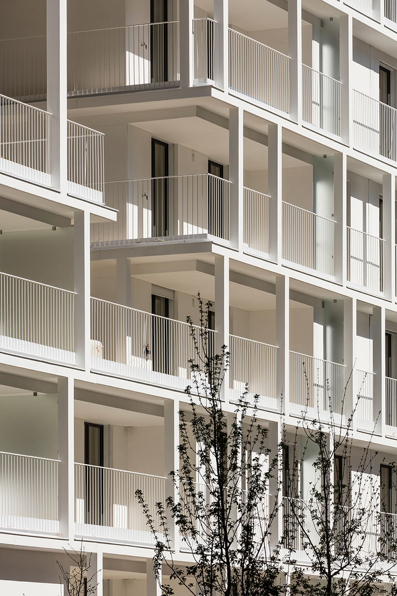 a white concrete exoskeleton frames AAVP's residential complex in paris designboom