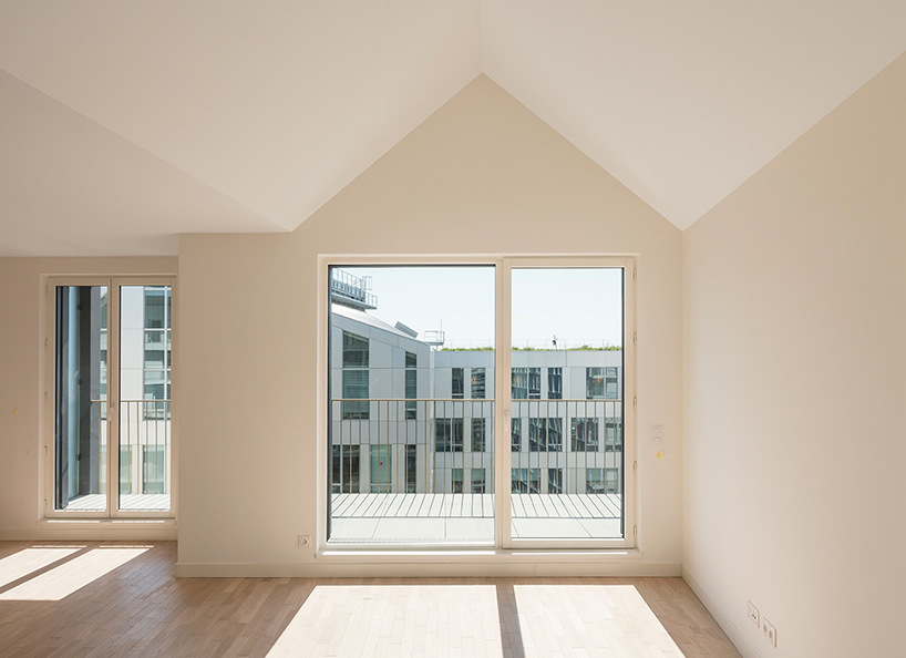 a white concrete exoskeleton frames AAVP's residential complex in paris designboom