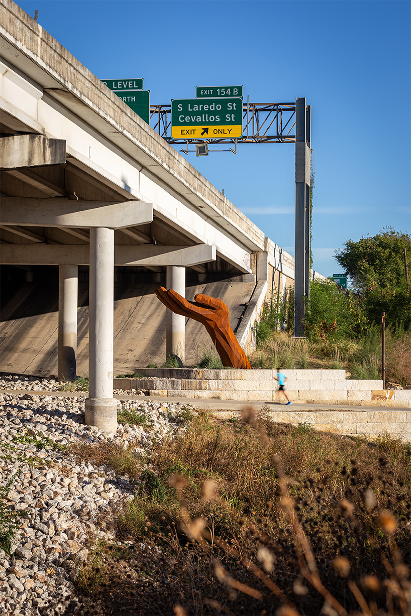mark reigelman's oversized hand sculpture captures runoff water from overpass in texas