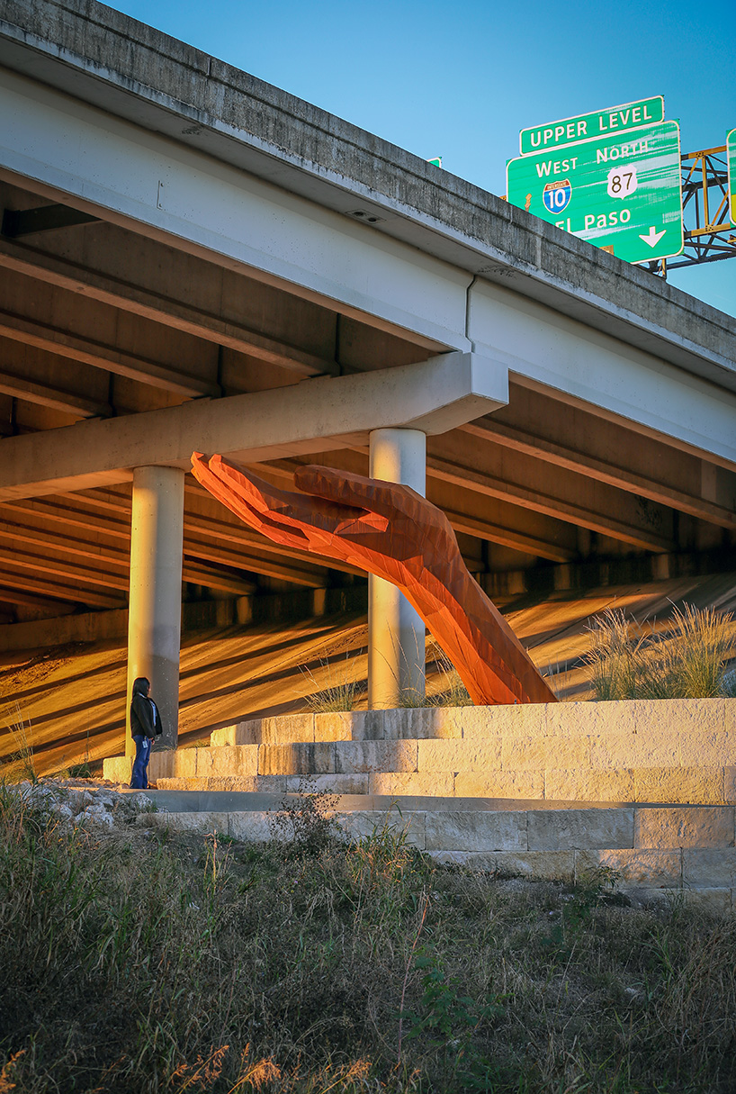 mark reigelman's oversized hand sculpture captures runoff water from overpass in texas