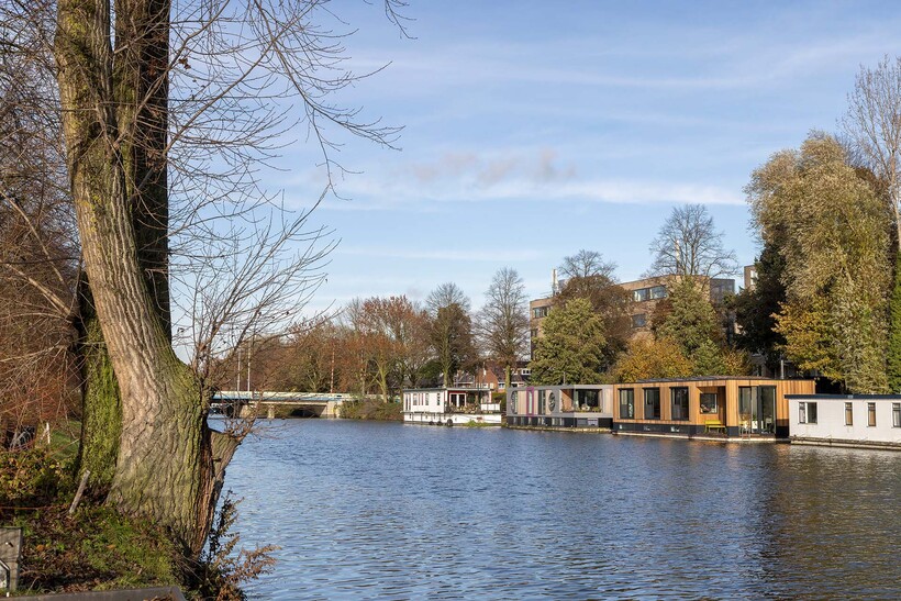 floating wooden houseboat by EVA architecten embraces canal views in utrecht