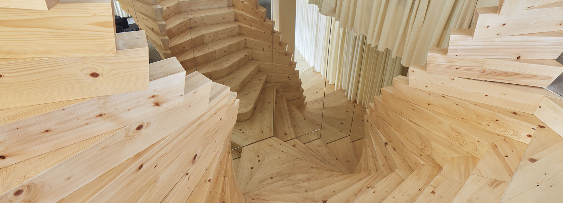 acme installs massive timber staircase with winding mirrors in its london studio