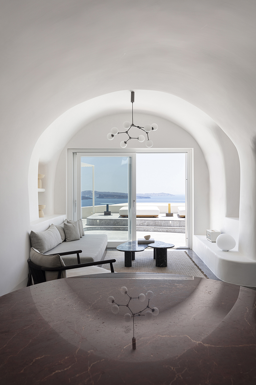 kapsimalis architects’ summer house in santorini emerges from a cliffside cave