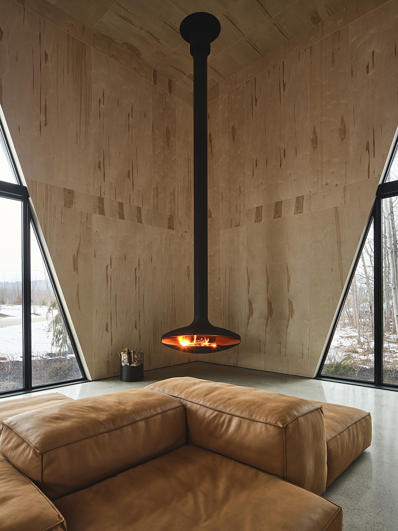 charred wood ski chalet by atelier RZLBD tucks into sloping terrain in rural canada