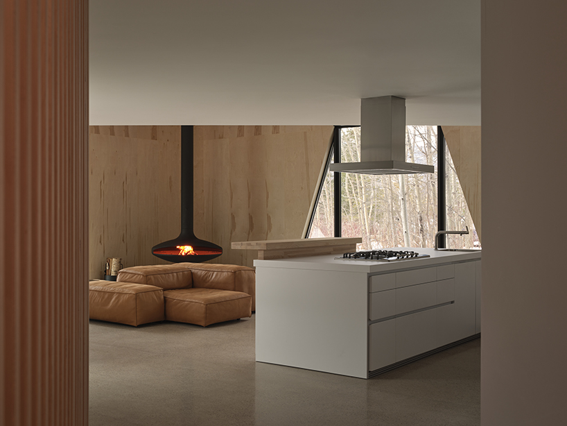 charred wood ski chalet by atelier RZLBD tucks into sloping terrain in rural canada