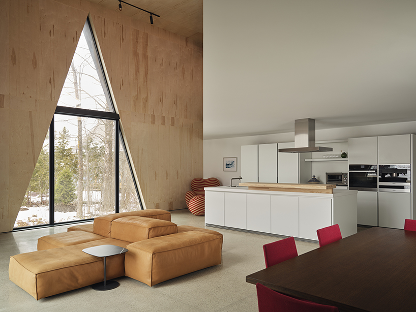 charred wood ski chalet by atelier RZLBD tucks into sloping terrain in rural canada