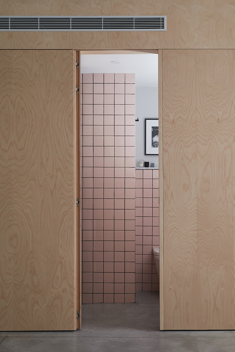 this apartment in tel aviv uses a wooden storage unit to separate private spaces - 8
