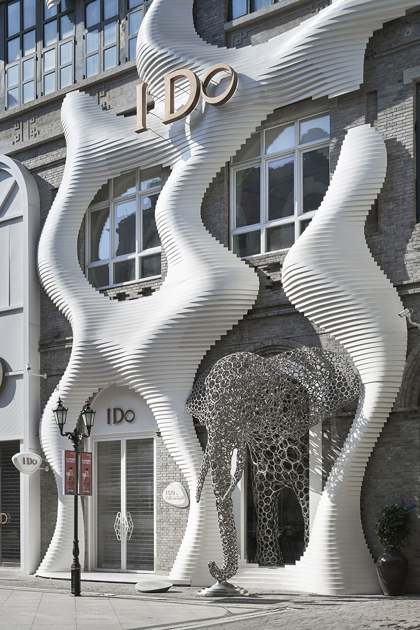 life-size steel lattice elephant pops out of antistatics' retail store façade in china