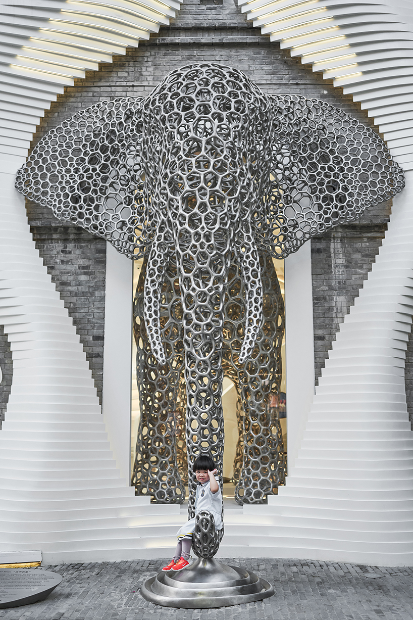 life-size steel lattice elephant pops out of antistatics' retail store façade in china