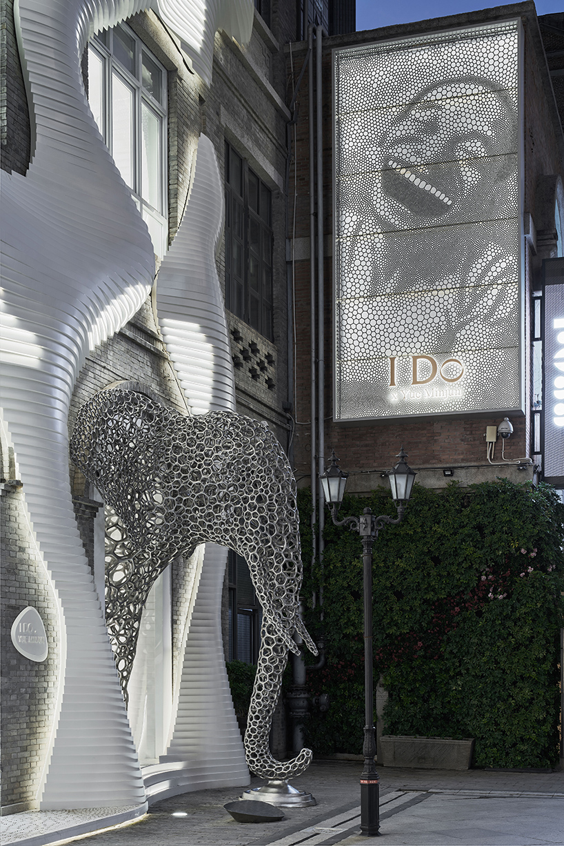 life-size steel lattice elephant pops out of antistatics' retail store façade in china