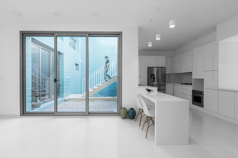 ayeneh office's house in iran takes shape around a central yard clad in blue tiles and bricks