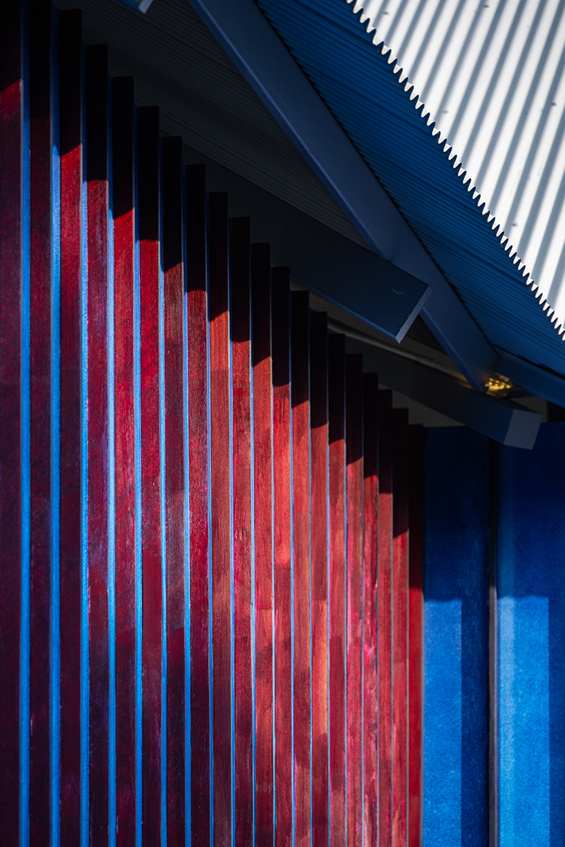 sher maker tops pleated wood longhouse with steel roof for fashion studio in chiang mai