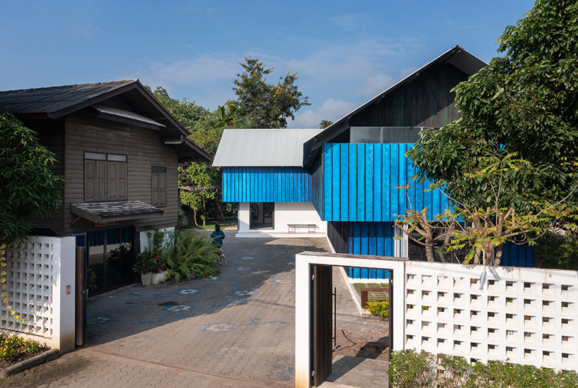 sher maker tops pleated wood longhouse with steel roof for fashion studio in chiang mai