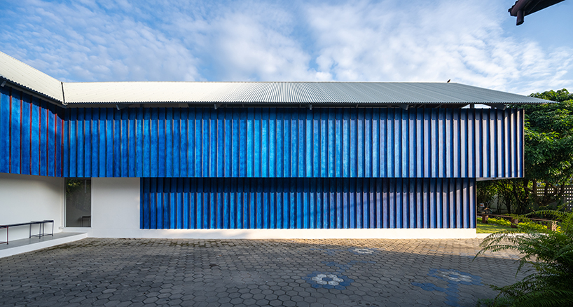 sher maker tops pleated wood longhouse with steel roof for fashion studio in chiang mai