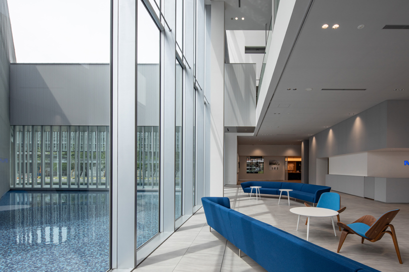 this transparent showroom in japan is surrounded by an artificial pond takenaka designboom