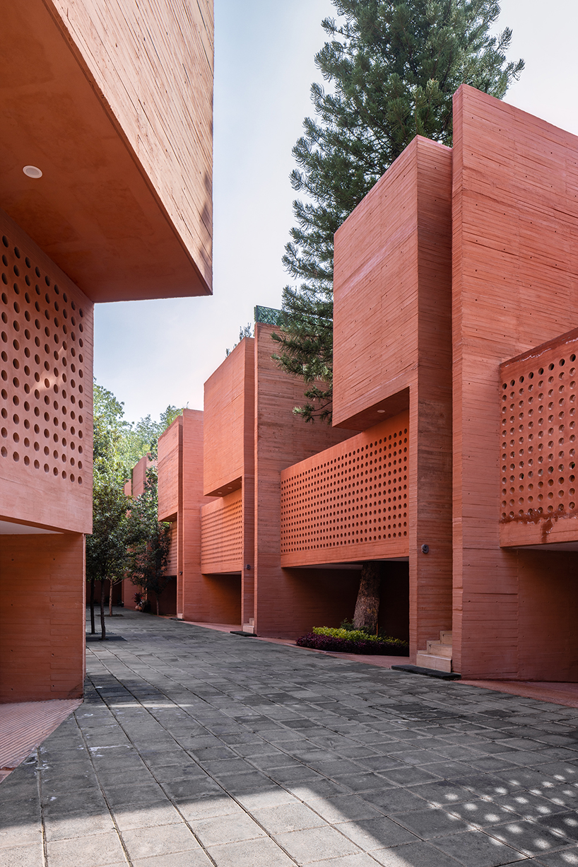 orange-tinted concrete blocks stack residential complex in mexico, image size:818x1226
