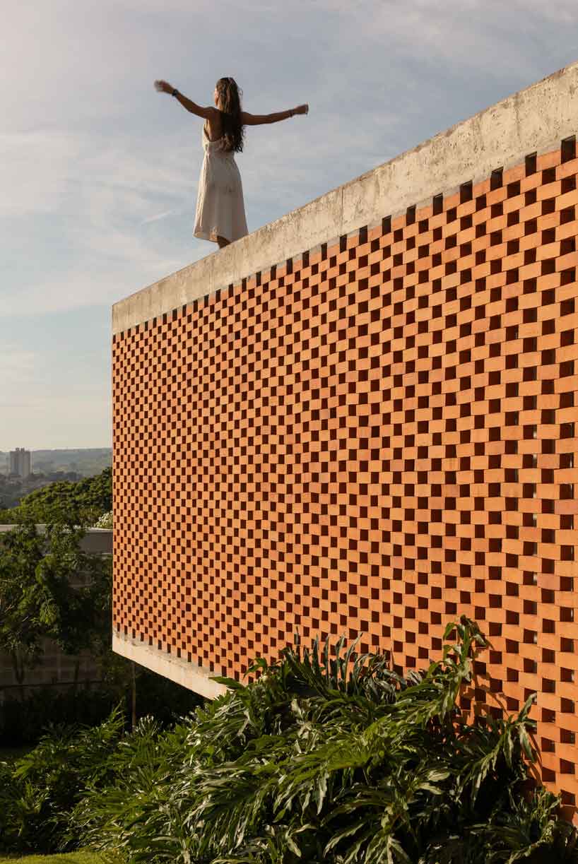 perforated brick facade punctuates fernanda padula’s concrete house in brazil