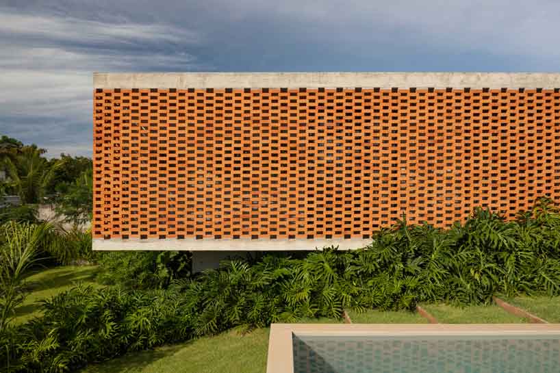 perforated brick facade punctuates fernanda padula’s concrete house in brazil