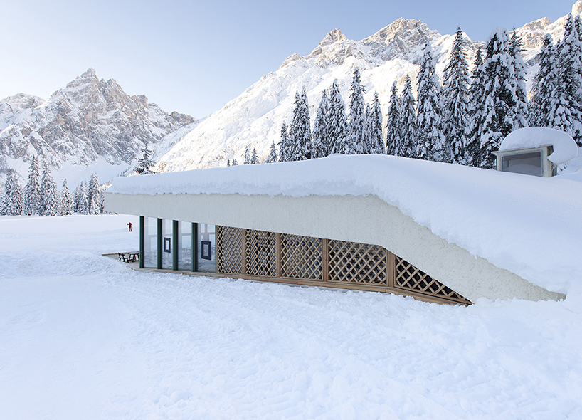 local larch wood + stone clad plasma studio's bistro anchored in dolomites' landscape