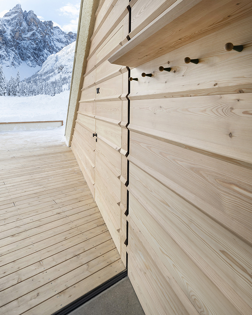 local larch wood + stone clad plasma studio's bistro anchored in dolomites' landscape