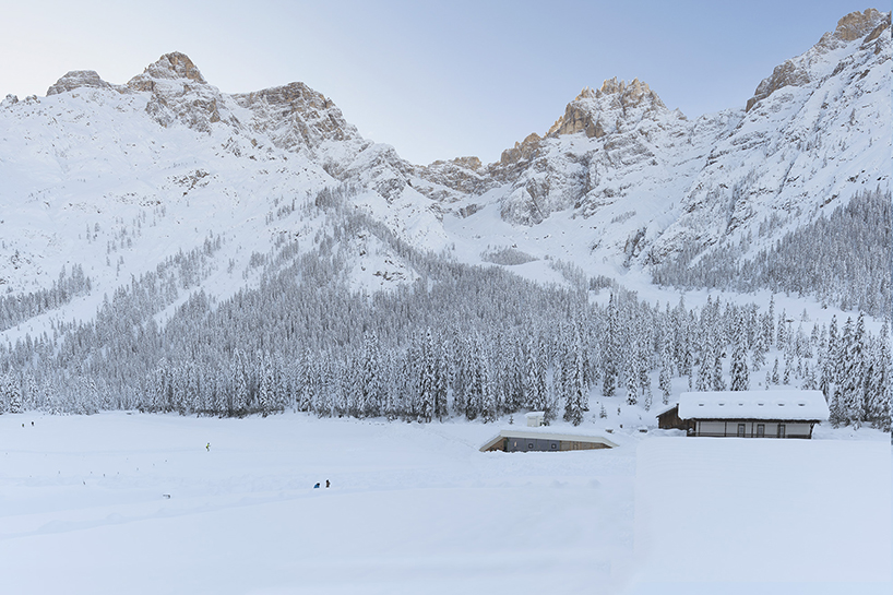 local larch wood + stone clad plasma studio's bistro anchored in dolomites' landscape