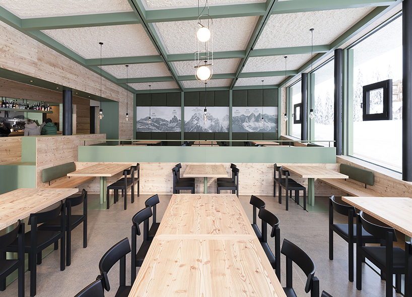 local larch wood + stone clad plasma studio's bistro anchored in dolomites' landscape