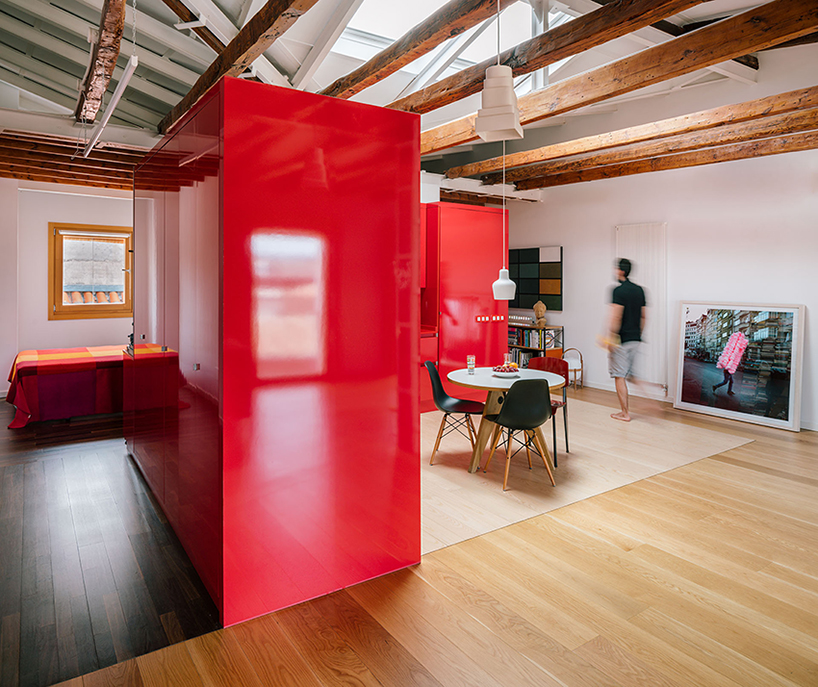 gon architects inserts a bright red, continuous furniture to articulate attic in madrid