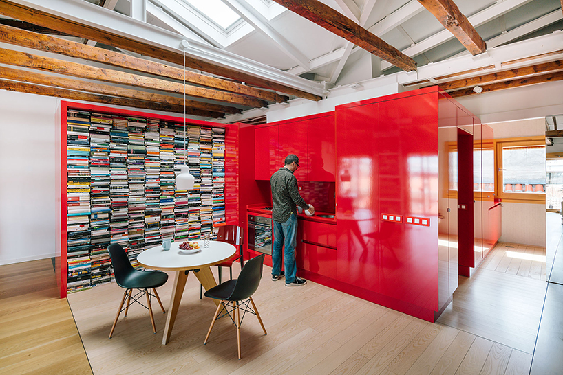 gon architects inserts a bright red, continuous furniture to articulate attic in madrid