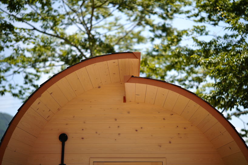 thinned trees from japanese forest compose kairi eguchi studio's barrel-shaped sauna with stepped ceiling