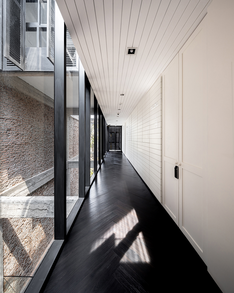 IDIN architects completes pa prank hostel in bangkok with façade of black shutters