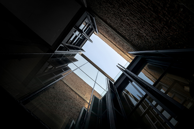 IDIN architects completes pa prank hostel in bangkok with façade of black shutters