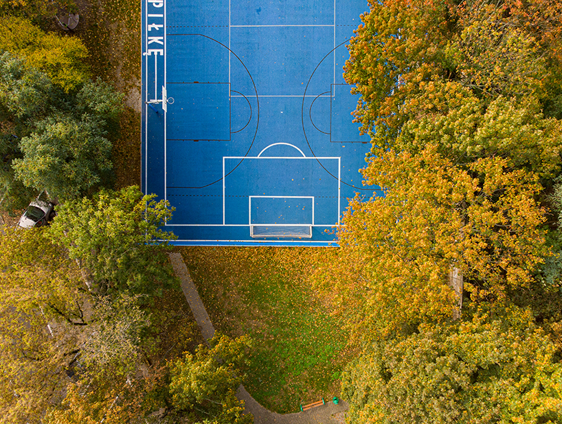 UGO completes a bright blue sports field in poznan, poland designboom