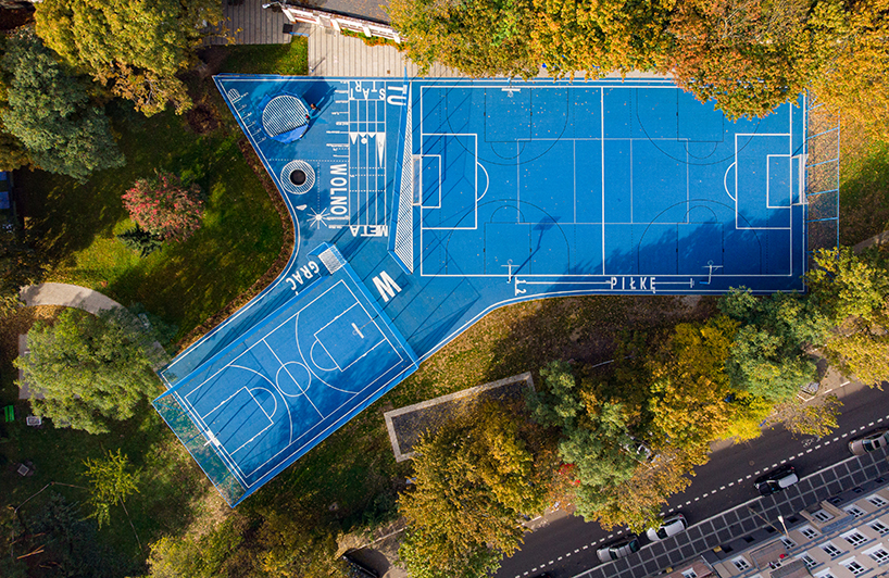 UGO completes a bright blue sports field in poznan, poland designboom