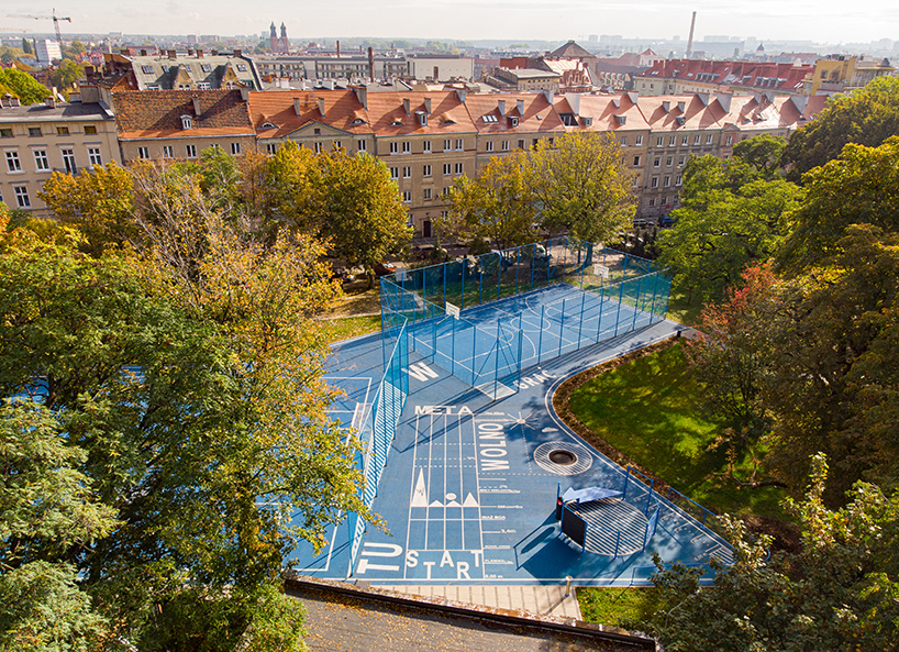UGO completes a bright blue sports field in poznan, poland designboom