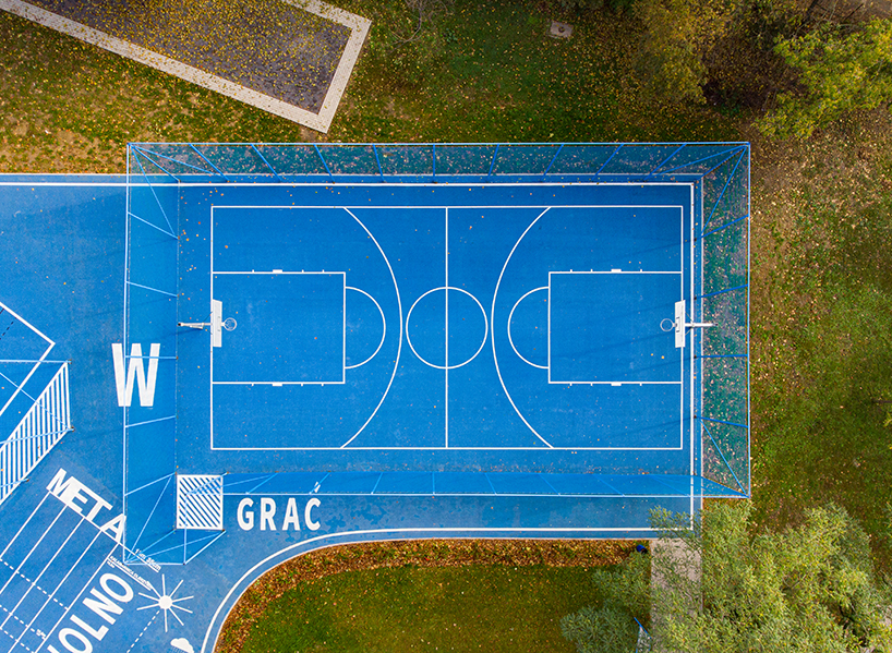 UGO completes a bright blue sports field in poznan, poland designboom