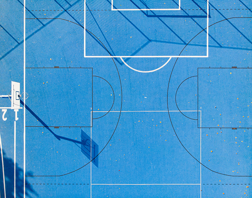 UGO completes a bright blue sports field in poznan, poland designboom