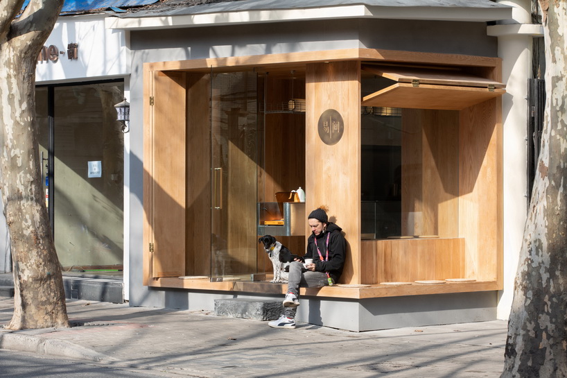golucci embeds serene wooden box café into the concrete urban fabric of shanghai