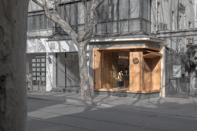 golucci embeds serene wooden box café into the concrete urban fabric of shanghai