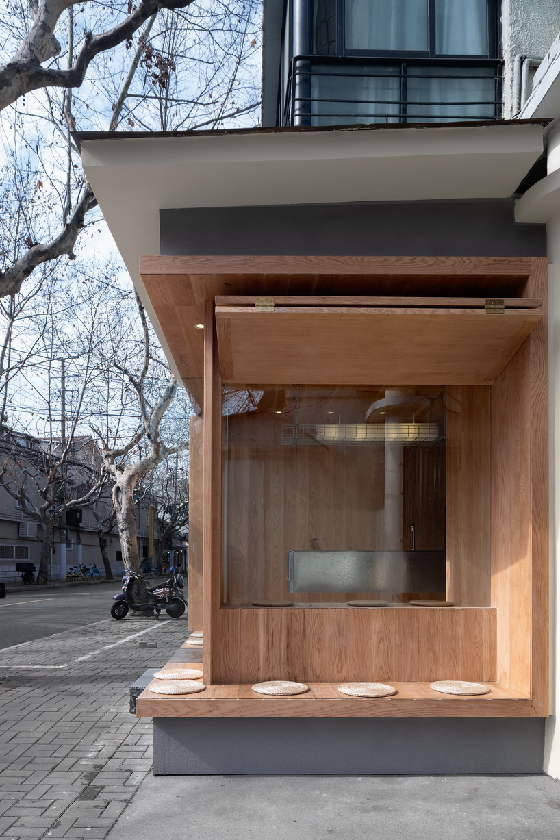 golucci embeds serene wooden box café into the concrete urban fabric of shanghai