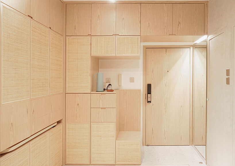 absence from island completes apartment interior in hong kong with rattan, wood + terrazzo