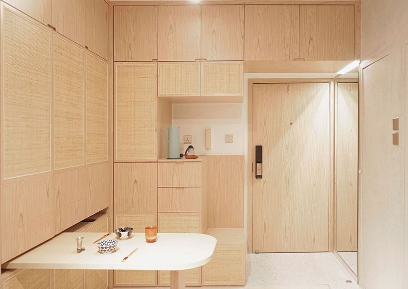 absence from island completes apartment interior in hong kong with rattan, wood + terrazzo