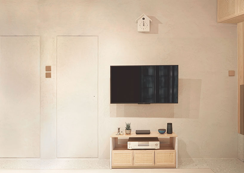 absence from island completes apartment interior in hong kong with rattan, wood + terrazzo